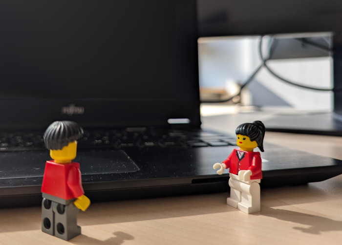 Zwei Lego Figuren stehen vor einem Laptop.